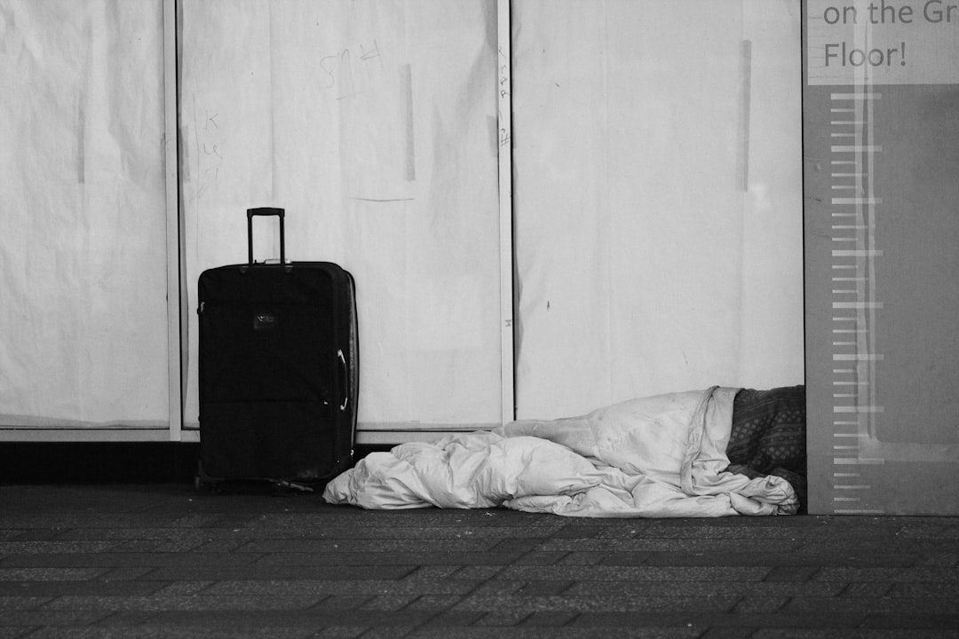 black luggage bag beside white bed