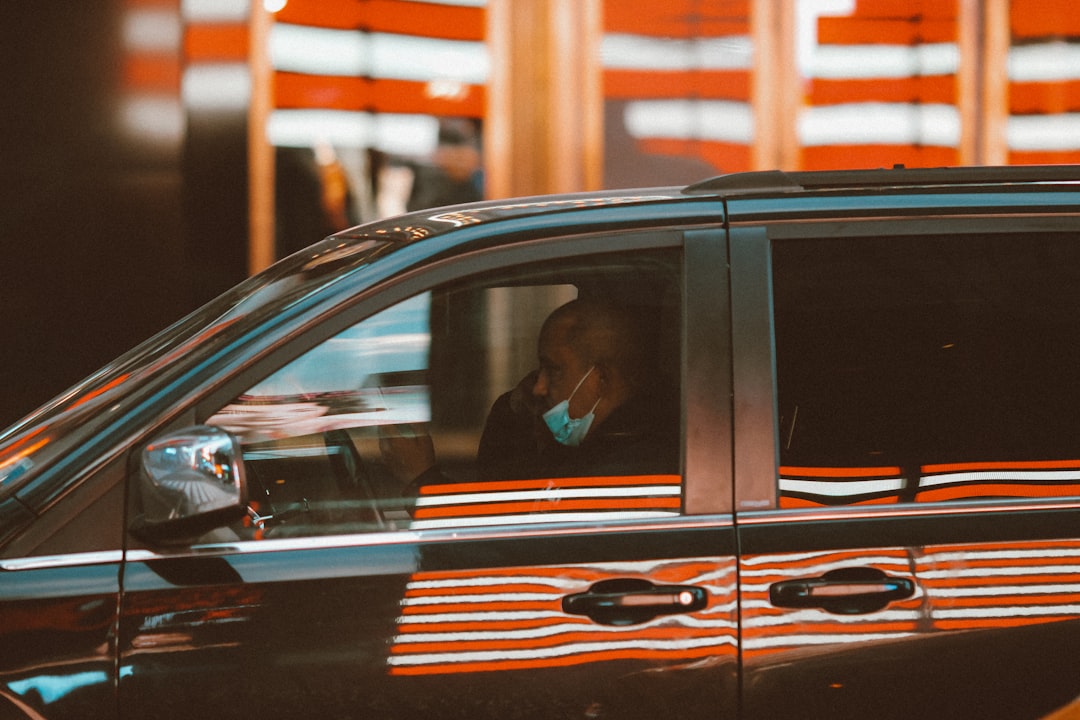 man in black jacket sitting inside car during daytime