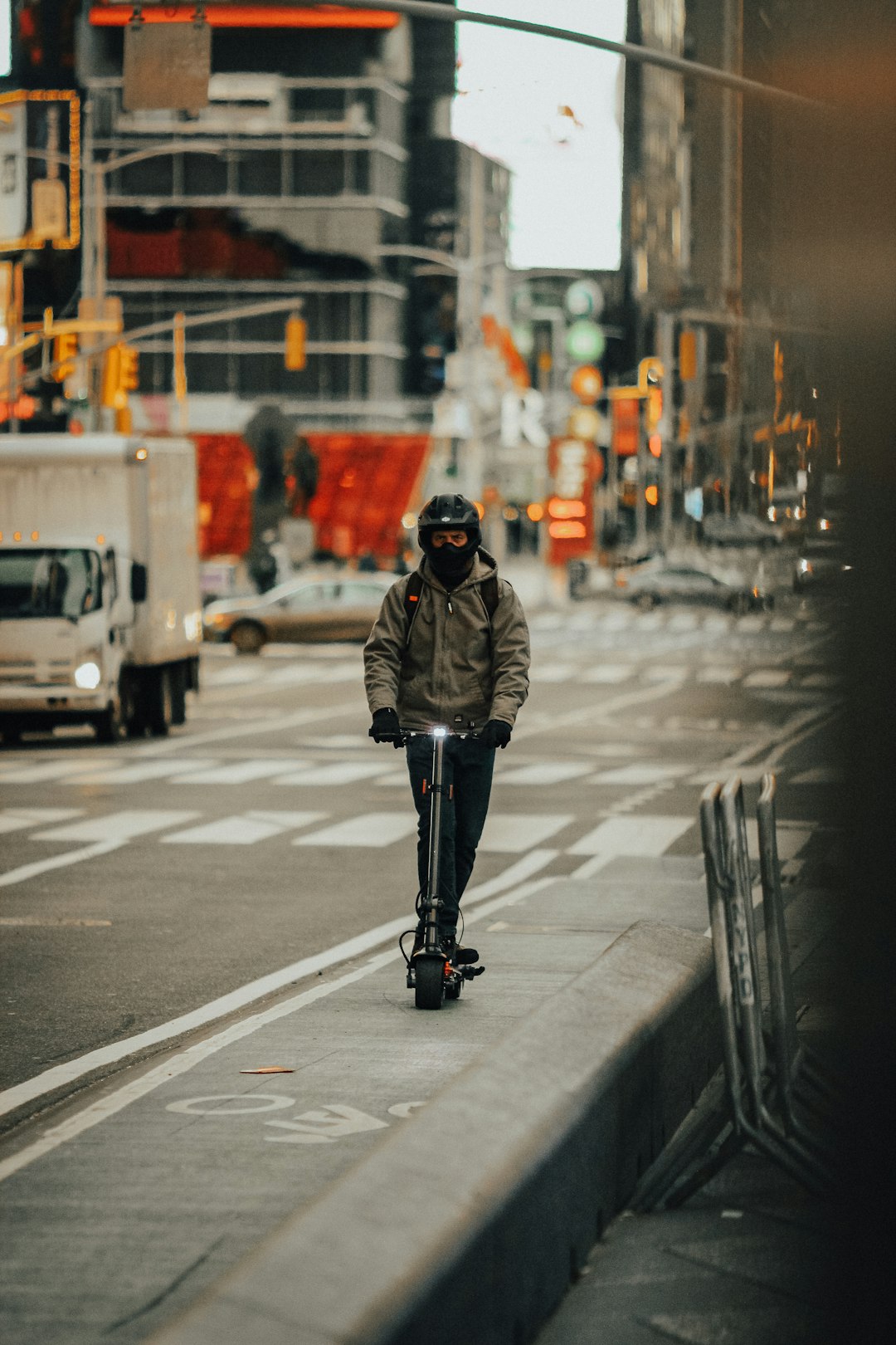 man in brown jacket and black pants walking on pedestrian lane during daytime