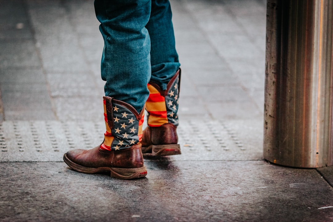 person in blue denim jeans and brown leather boots