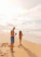Happy couple on a sunny beach enjoying their vacation organized by a travel agency