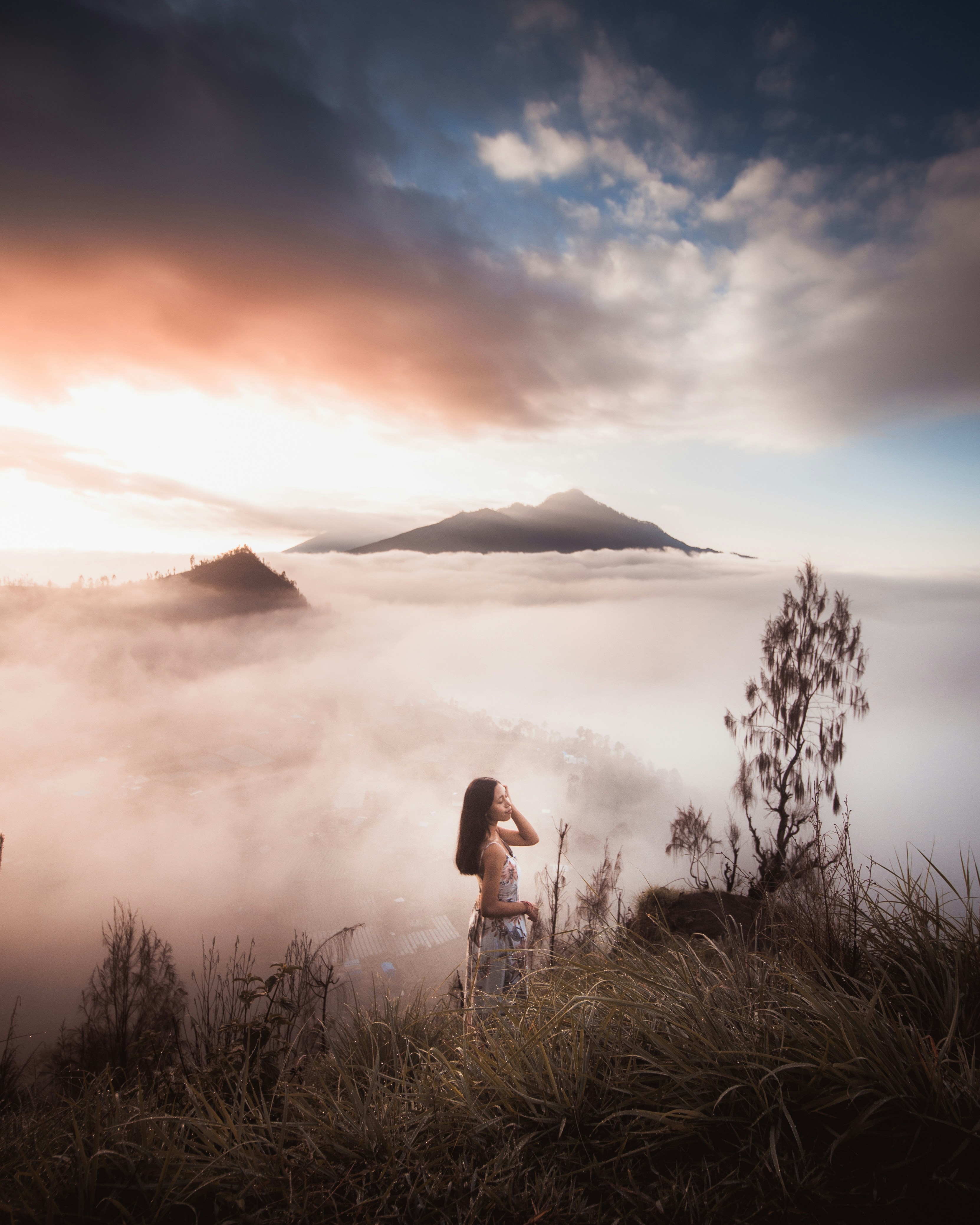 Woman in black tank top standing on green grass field during sunset ...