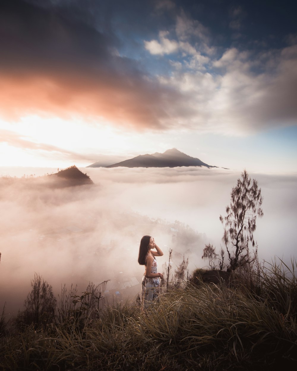 woman in black tank top standing on green grass field during sunset