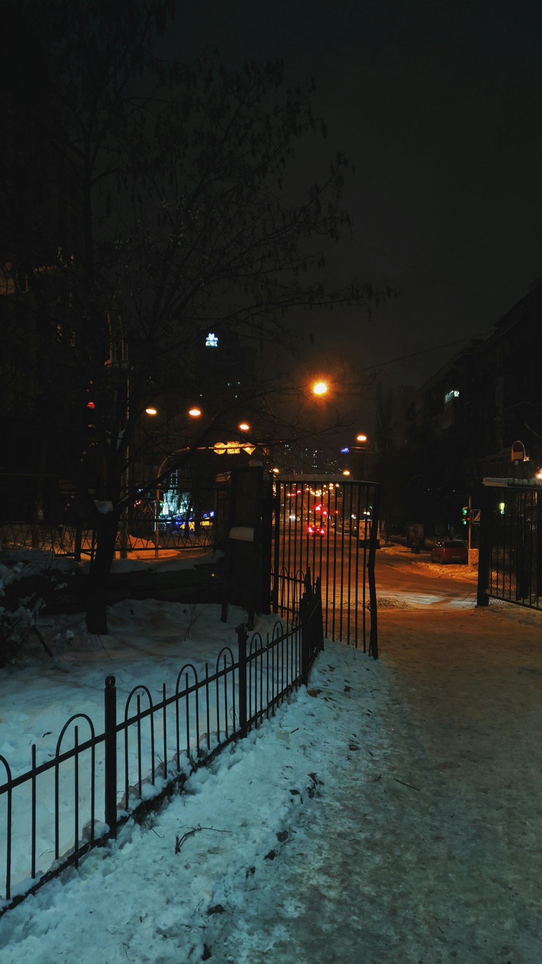 black metal fence on snow covered ground during night time