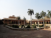 brown and white concrete building near palm trees during daytime