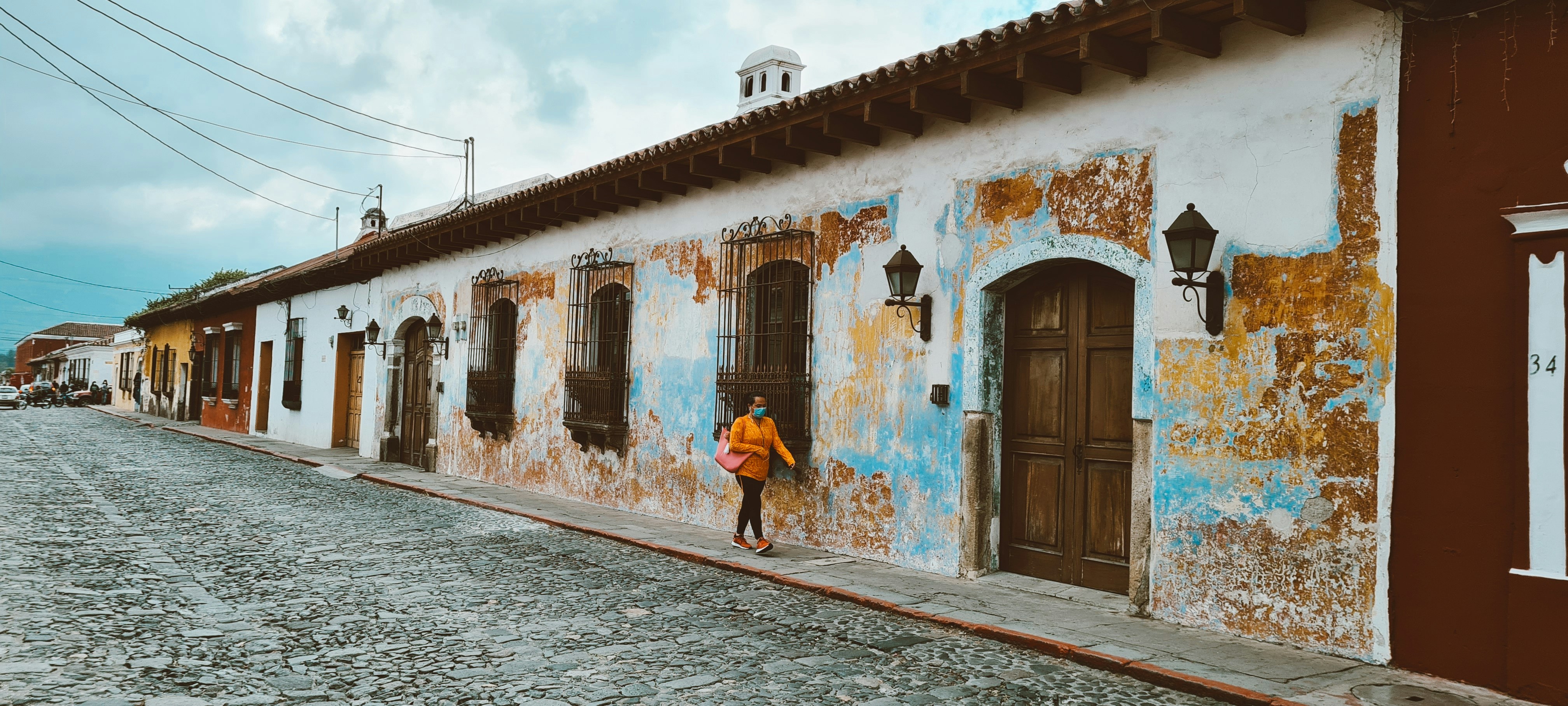 woman in blue dress walking on street during daytime, 