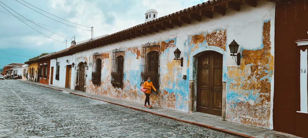 woman in blue dress walking on street during daytime