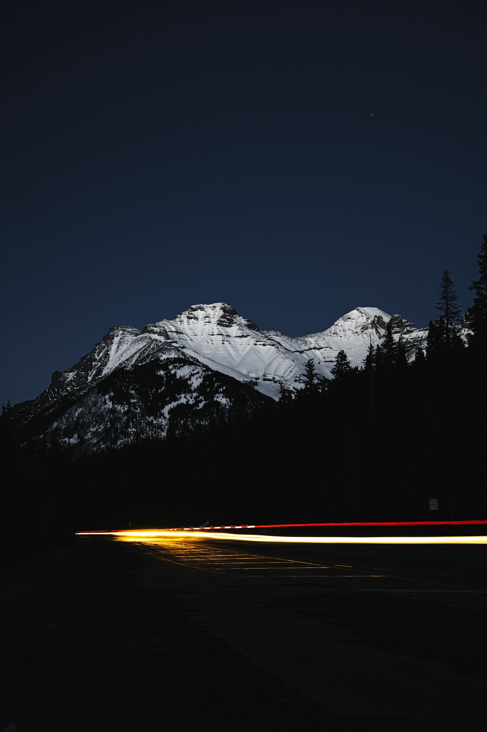 time lapse photography of road near snow covered mountain
