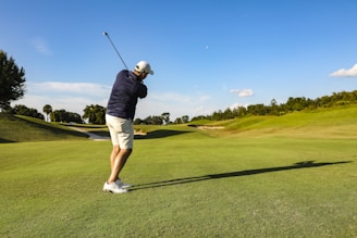 man in black t-shirt and white shorts playing golf during daytime
