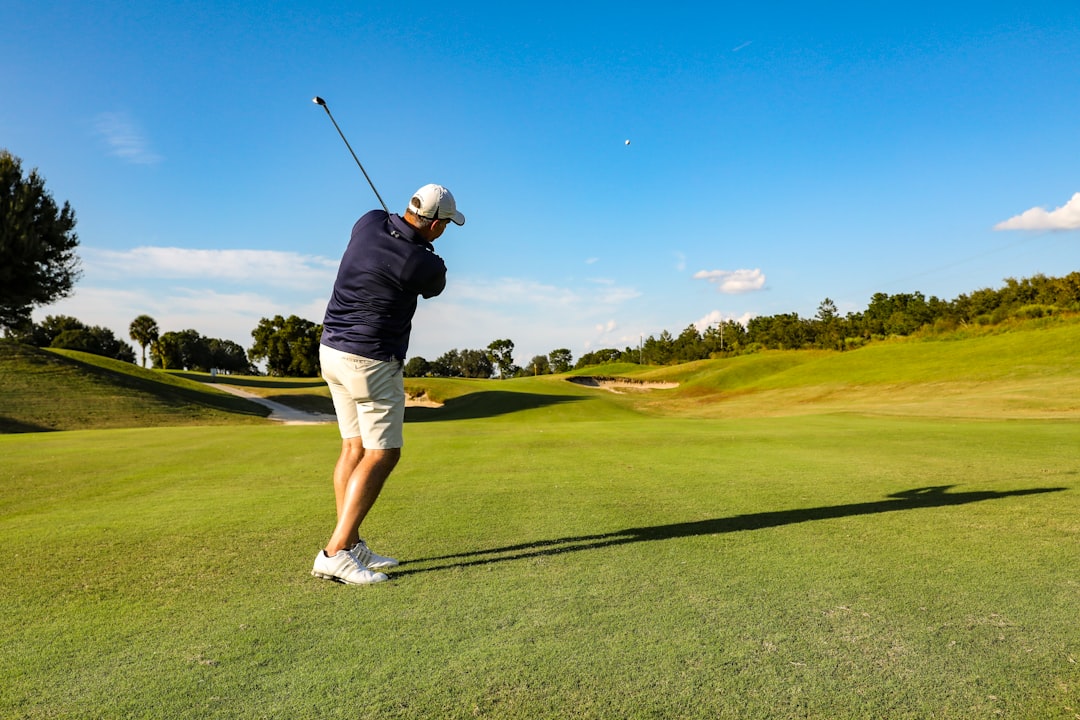 man in black t-shirt and white shorts playing golf during daytime