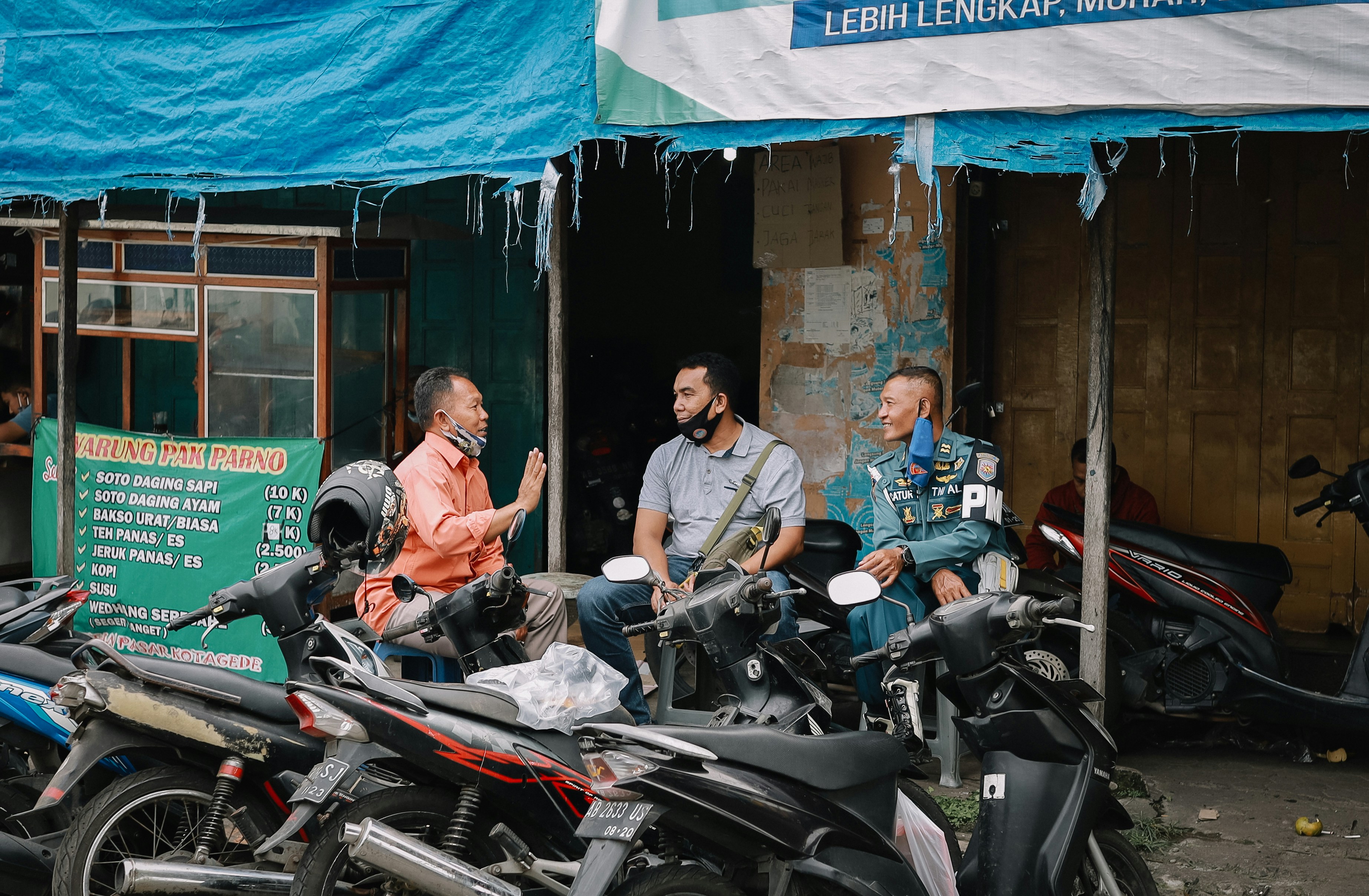 Orang yang mengendarai sepeda motor di jalan pada siang hari