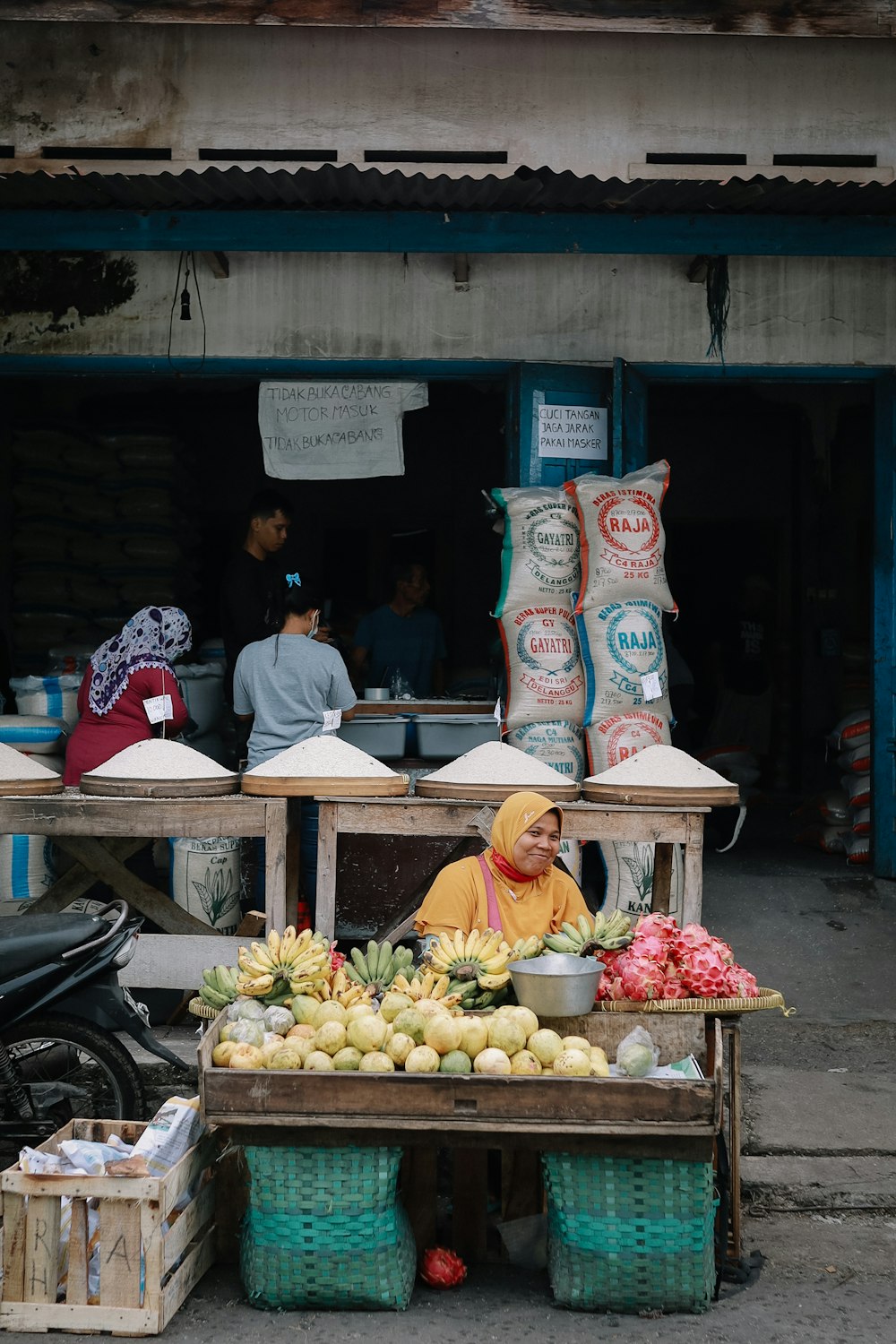 woman in yellow hijab sitting on black motorcycle