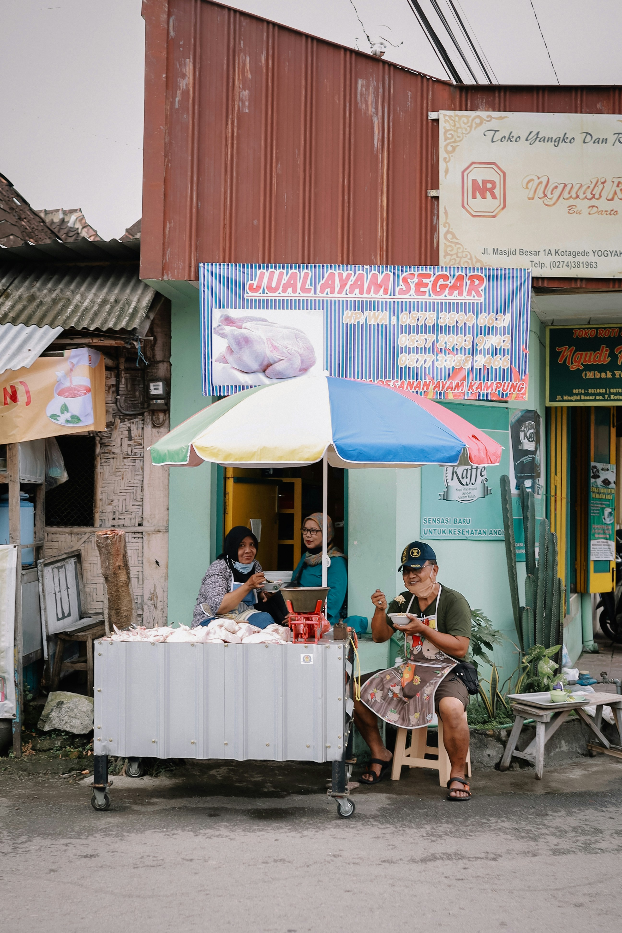Orang-orang yang duduk di kursi dekat gedung merah pada siang hari