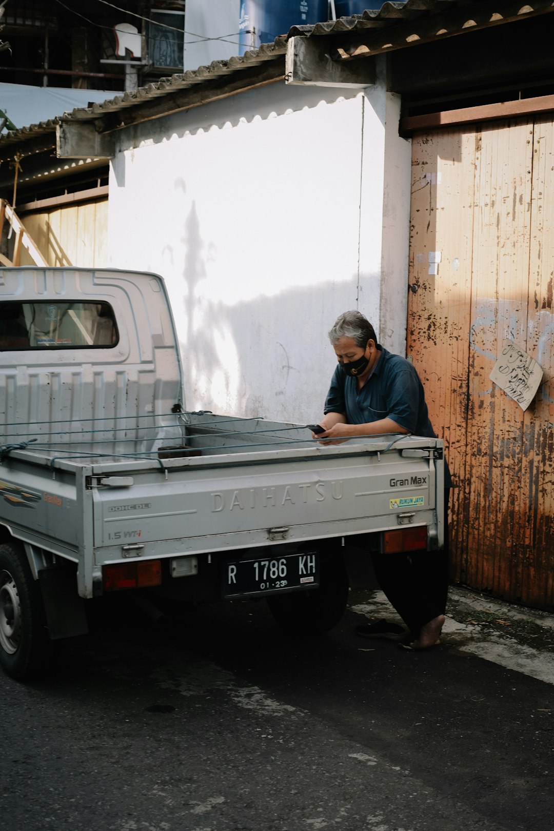 man in blue jacket sitting on white truck