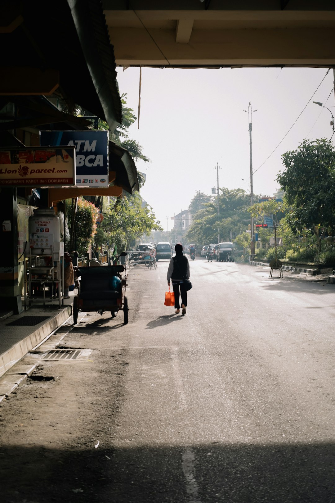 man in black jacket and black pants walking on gray concrete road during daytime