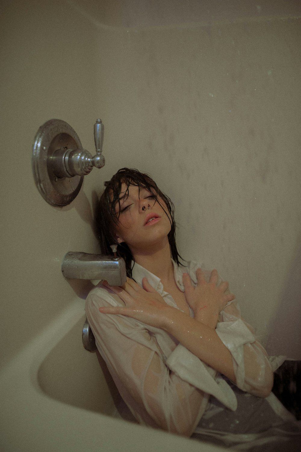 woman in white bath robe holding shower head