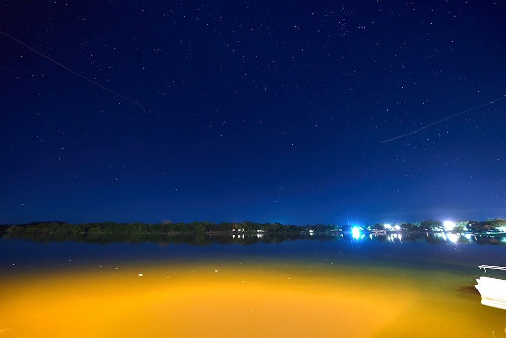 body of water near city lights during night time