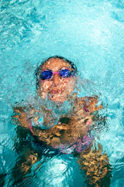 woman in green and black floral bikini top wearing blue sunglasses