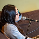 woman in gray long sleeve shirt sitting on brown chair
