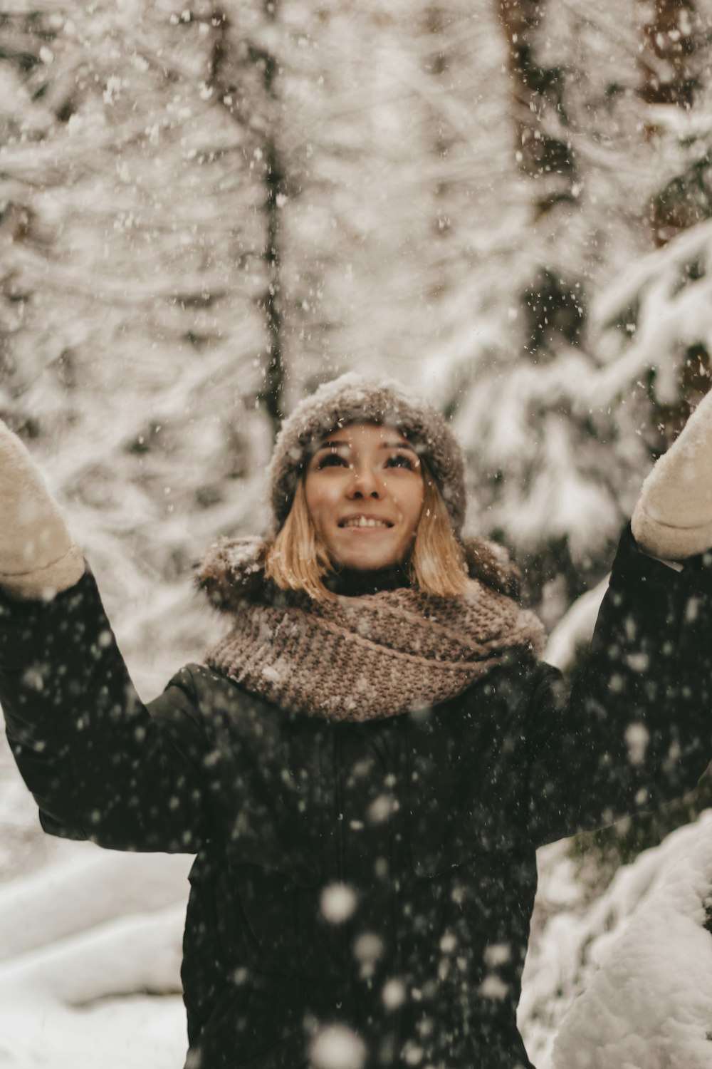 woman in black and white winter coat standing on snow covered ground during daytime