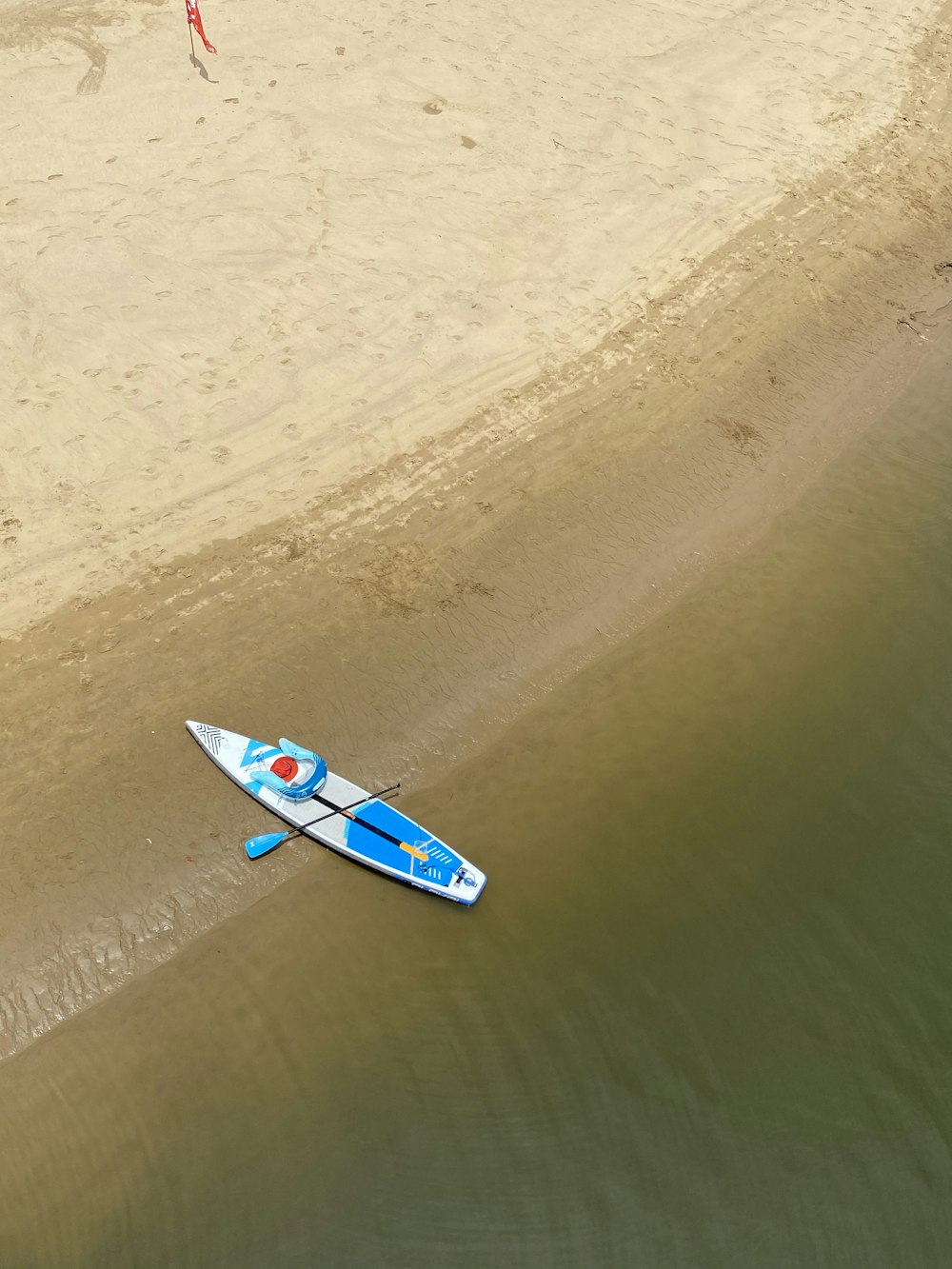 yellow and red kayak on brown sand