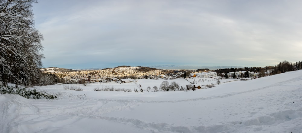 snow covered field under cloudy sky during daytime