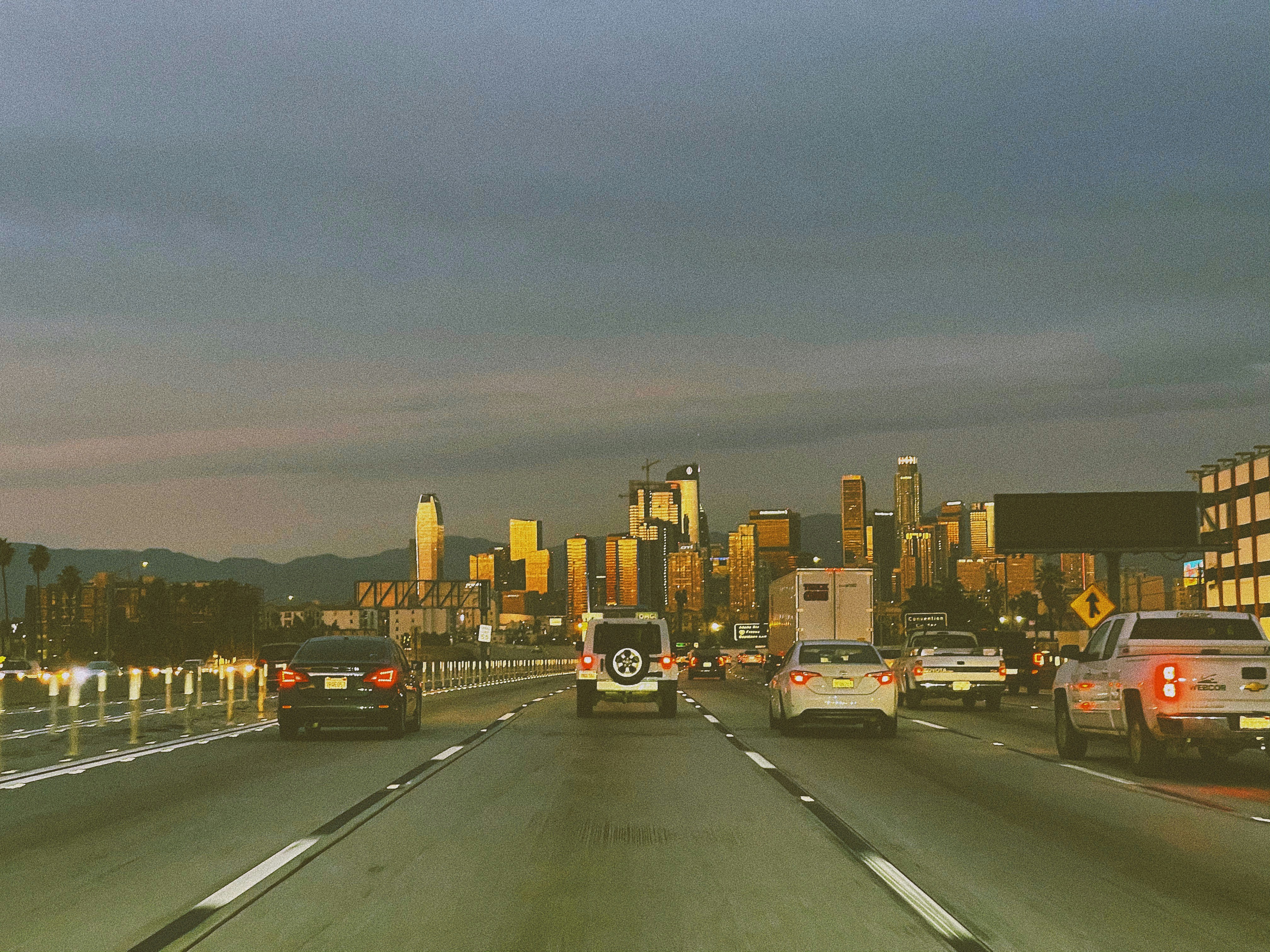 cars on road near city buildings during daytime