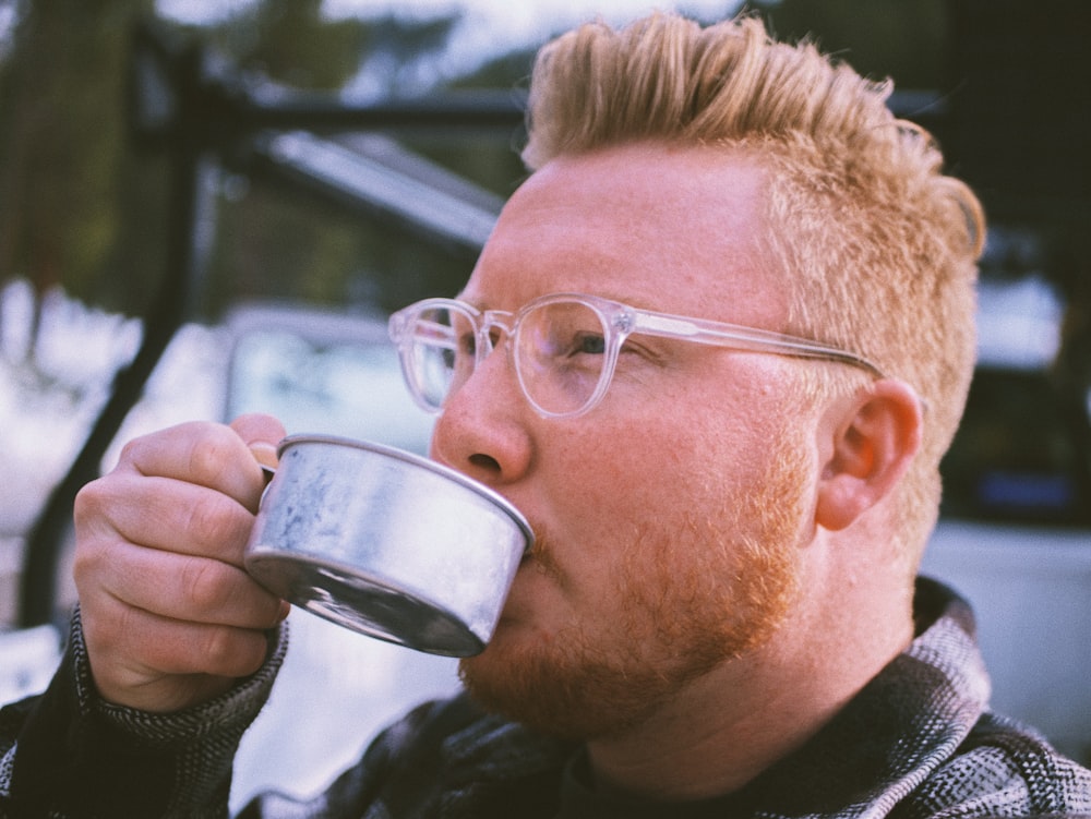 man in black sweater drinking from white ceramic mug