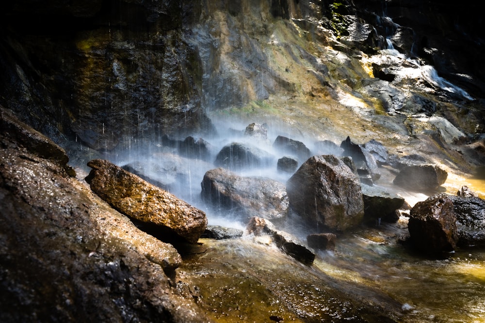 water falls on rocky mountain during daytime