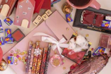 A flat lay of assorted party favors and tokens styled with confetti and colorful ribbons.