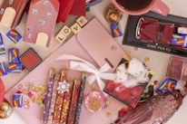 A colorful flat lay of stylish home decor items mixed with playful kids' toys on a wooden table.