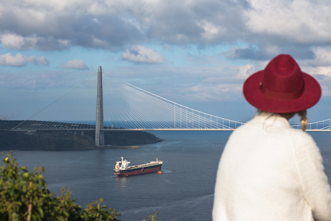 person in red cap and white shirt near bridge