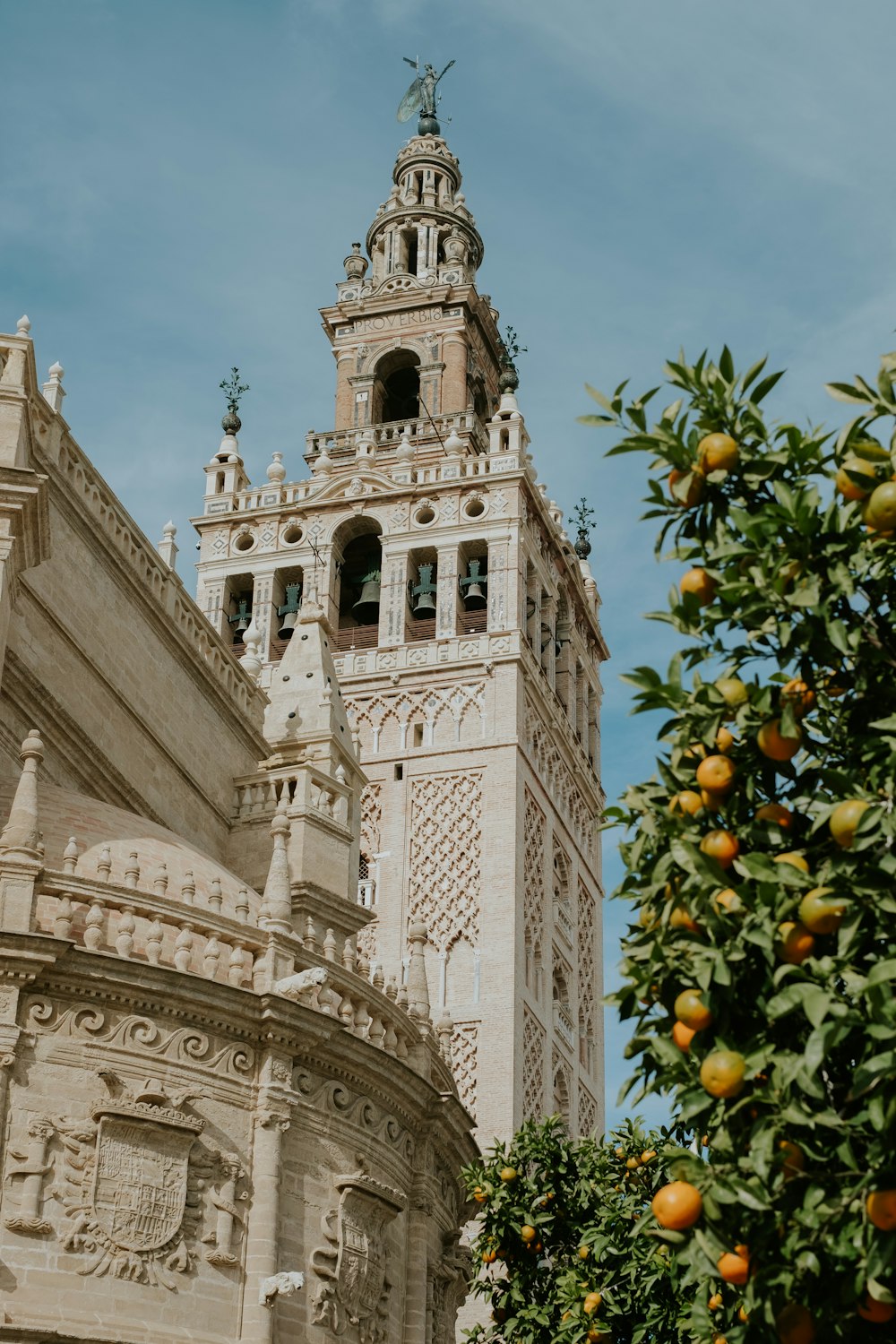 brown concrete building with orange and green fruits under blue sky during daytime