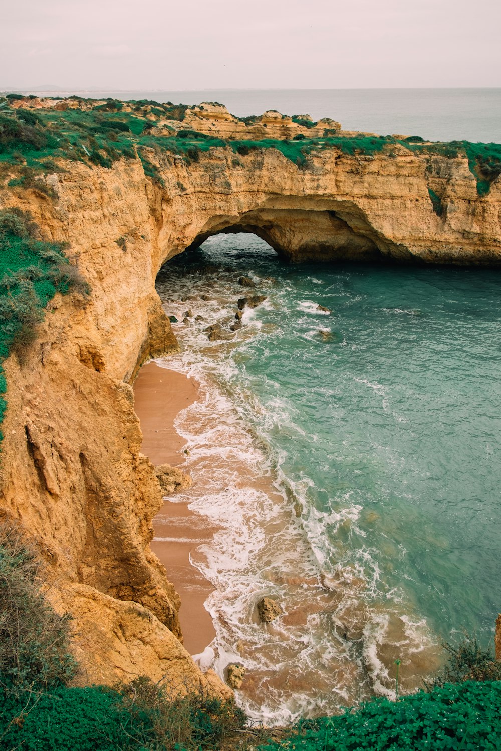 brown rock formation beside body of water during daytime