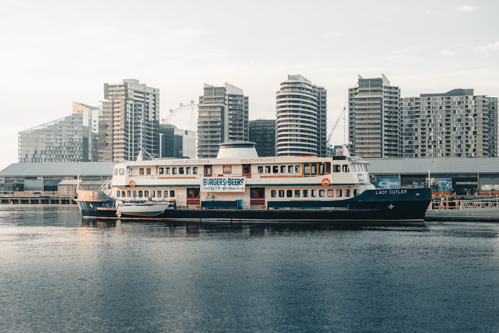 white and black boat on water near city buildings during daytime