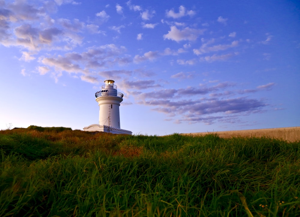 white lighthouse under blue sky and white clouds during daytime
