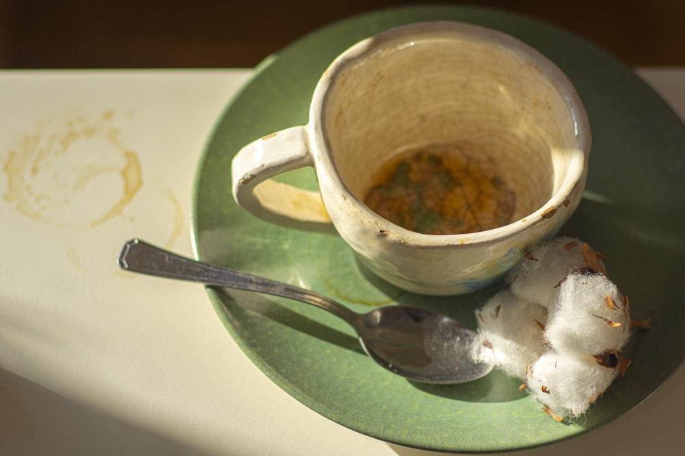 white ceramic mug on green ceramic saucer