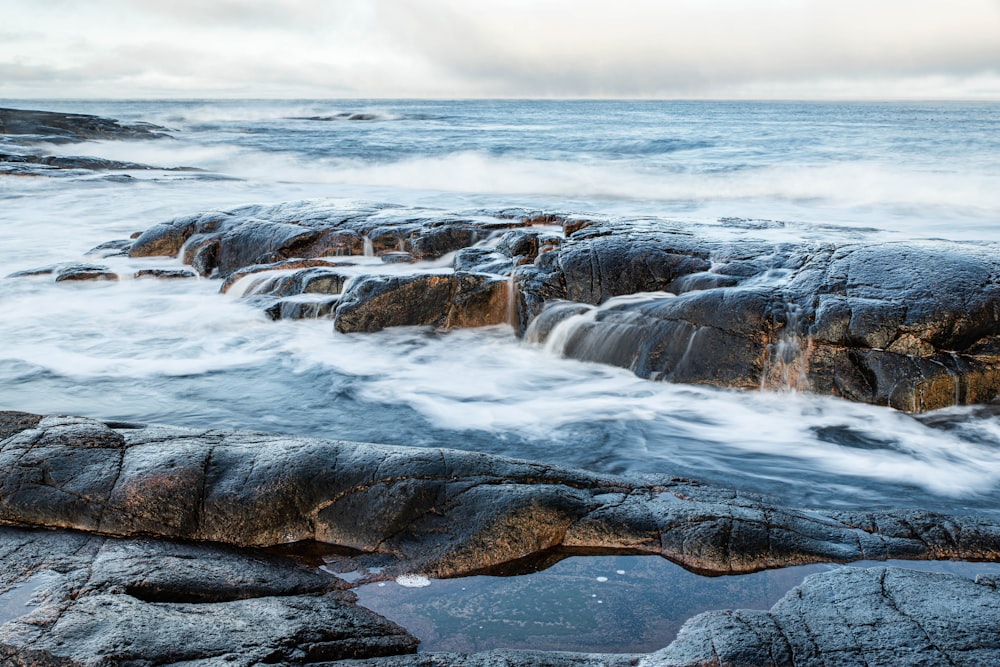 water falls under white sky during daytime