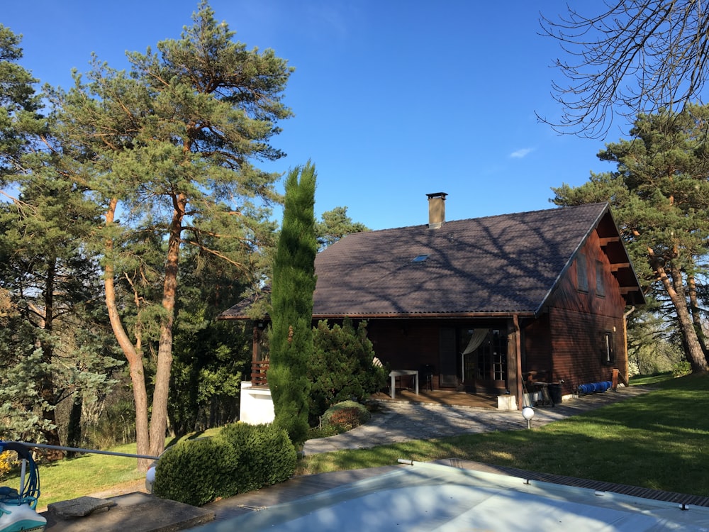 brown wooden house near green trees during daytime