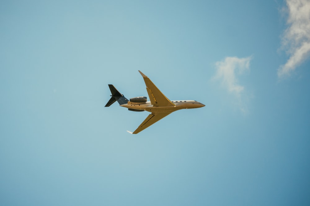 yellow and black plane flying in the sky