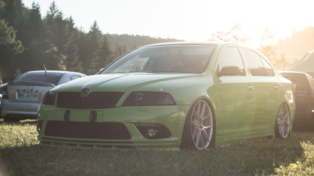 green chevrolet camaro on green grass field during daytime