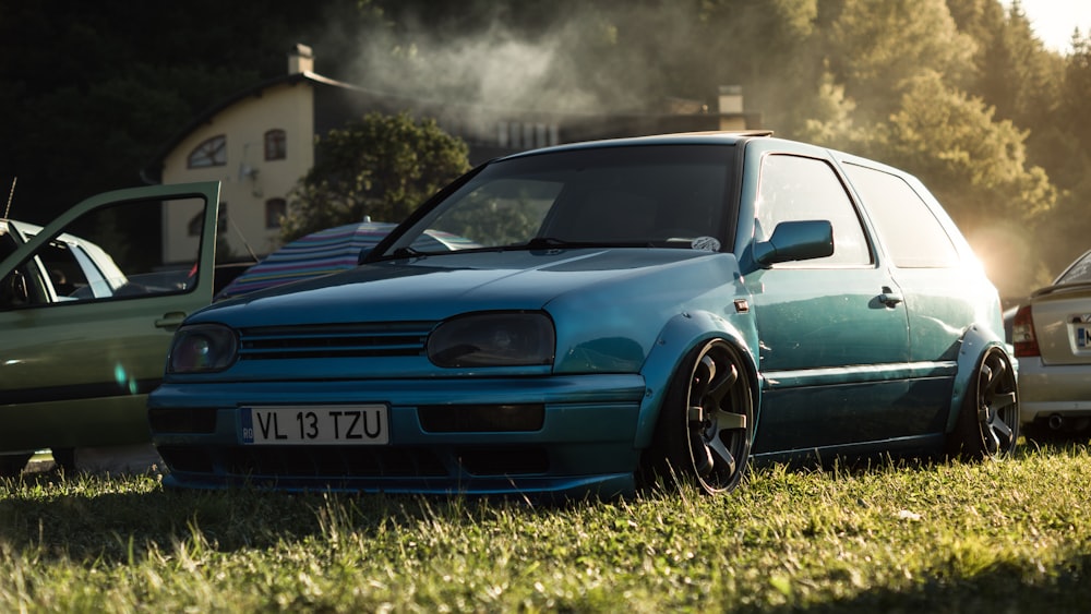 blue chevrolet camaro on green grass field during daytime