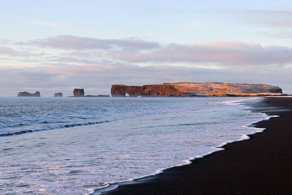 brown rock formation on sea water during daytime