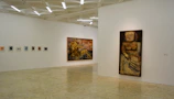 Minimalist exhibition space with soft neutral walls and spotlighted artworks.