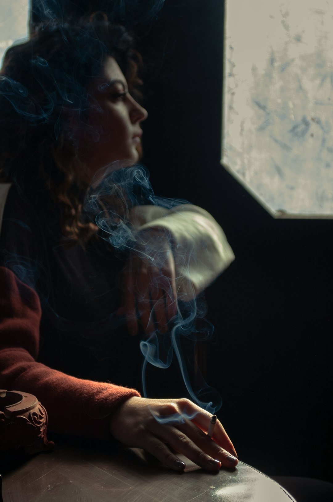 woman in red long sleeve shirt smoking