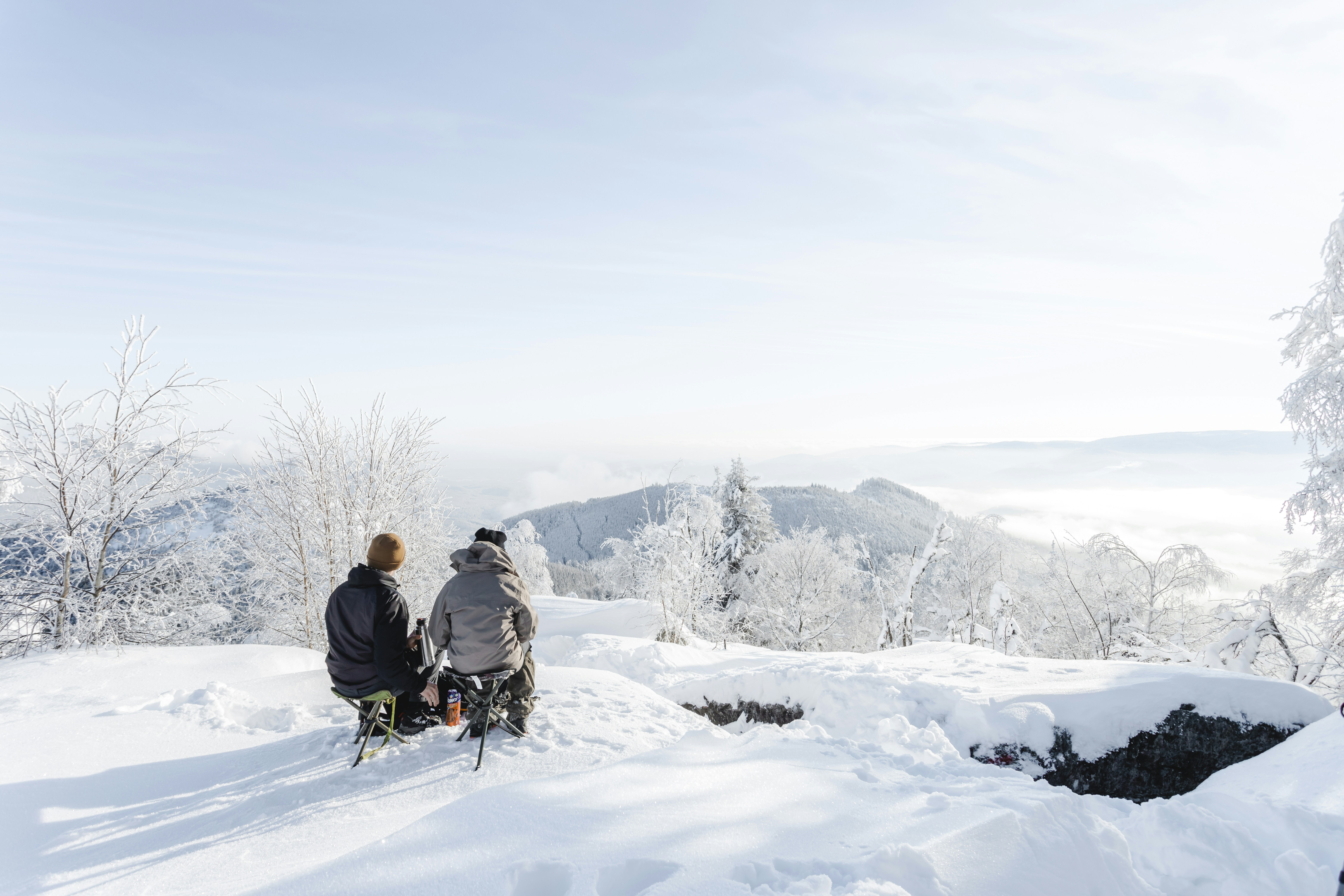 Two people taking a break on top of a mountain.
