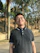 A smiling man wearing a crisp xelvano polo shirt standing outdoors on a sunny day.