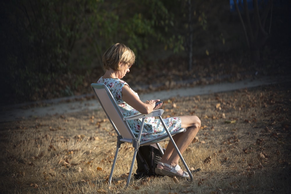 boy in blue tank top sitting on folding chair