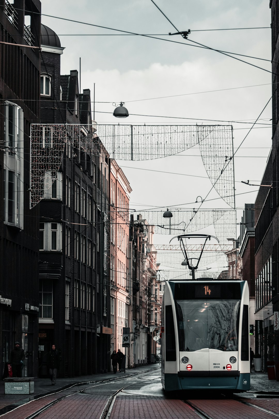 white and black cable car in between of buildings during daytime