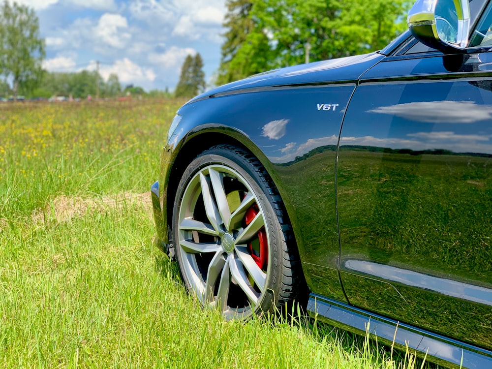 Auto blu sul campo di erba verde durante il giorno